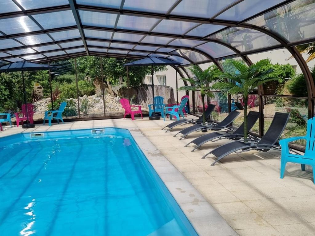 索米尔Les Chalets de SAUMUR, Piscine & Parc boisé, 100m du CadreNoir的一个带蓝色椅子的游泳池和一个游泳池