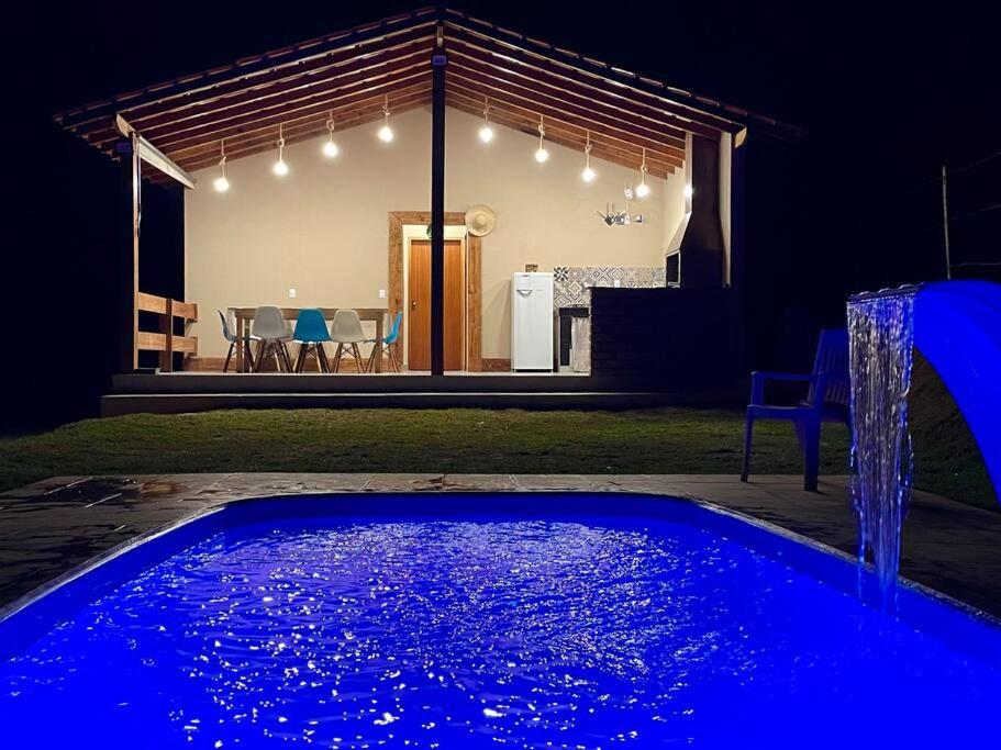 圣罗克Chácara prox Rota do Vinho com piscina, churrasqueira, área verde, animaizinhos e muito sossego的夜间在房子前面的游泳池