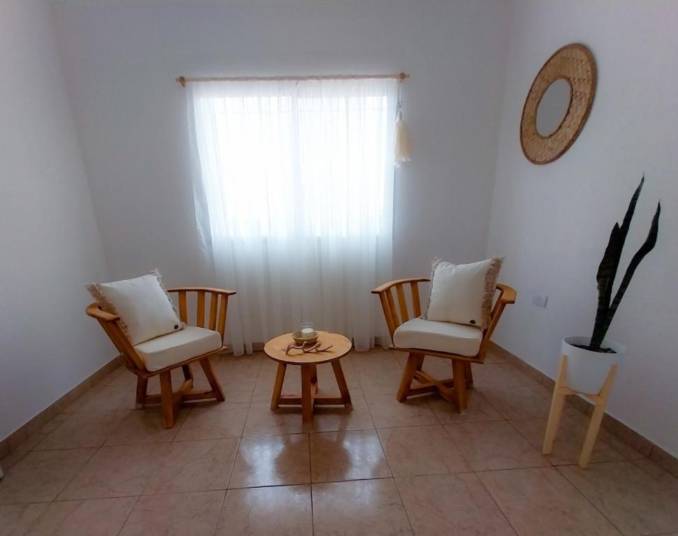 阿尔玛菲埃尔特Moras Morada的客厅配有椅子、桌子和窗户