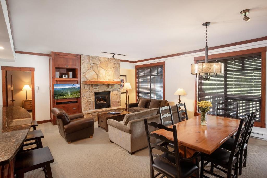 惠斯勒首迹旅舍的客厅配有桌子、沙发和壁炉
