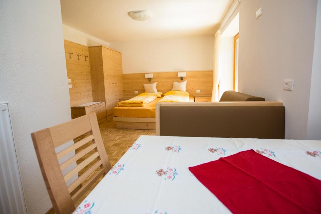 拉维拉哥泽安娜公寓的小房间设有两张床和一张带红色毛巾的桌子