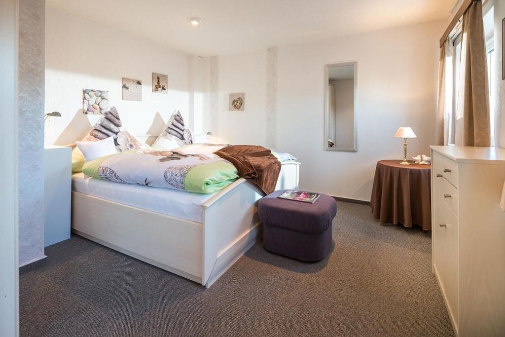 诺德奈Haus Naase App 3的一间卧室,里面放一张床和行李箱