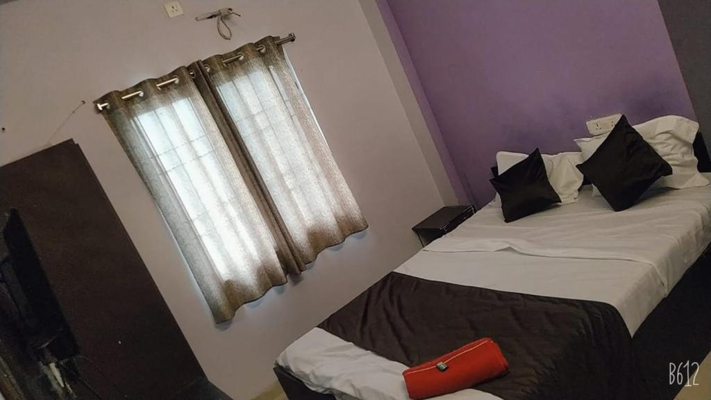 博帕尔Hotel sambhodhi palace的一间卧室设有两张床和窗户。