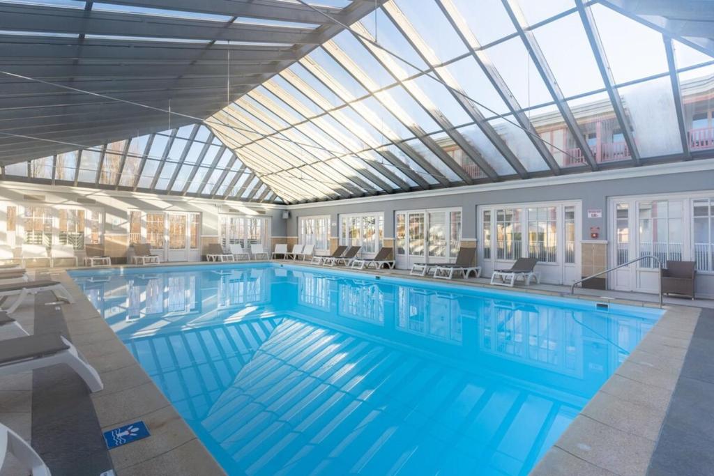 勒图凯-巴黎普拉日Appartement tout confort pour 5 pers avec piscine tennis et parking REF 232的一个带玻璃天花板的大型游泳池