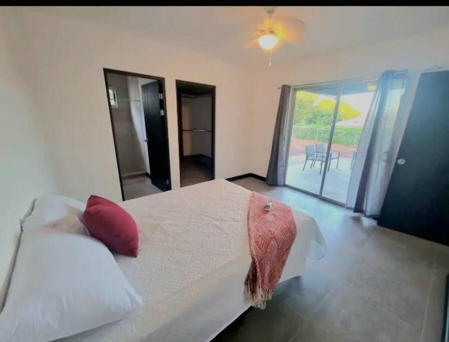 HuacasCastillo de Aslan. Casa nueva cerca de Playa Grande的卧室配有带红色枕头的大型白色床