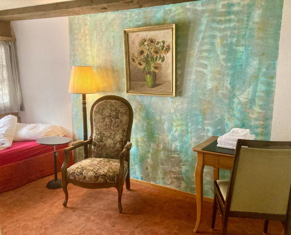 斯派克FriendsHouse Appenzellerhof的一间带椅子、一张床和一张桌子的房间