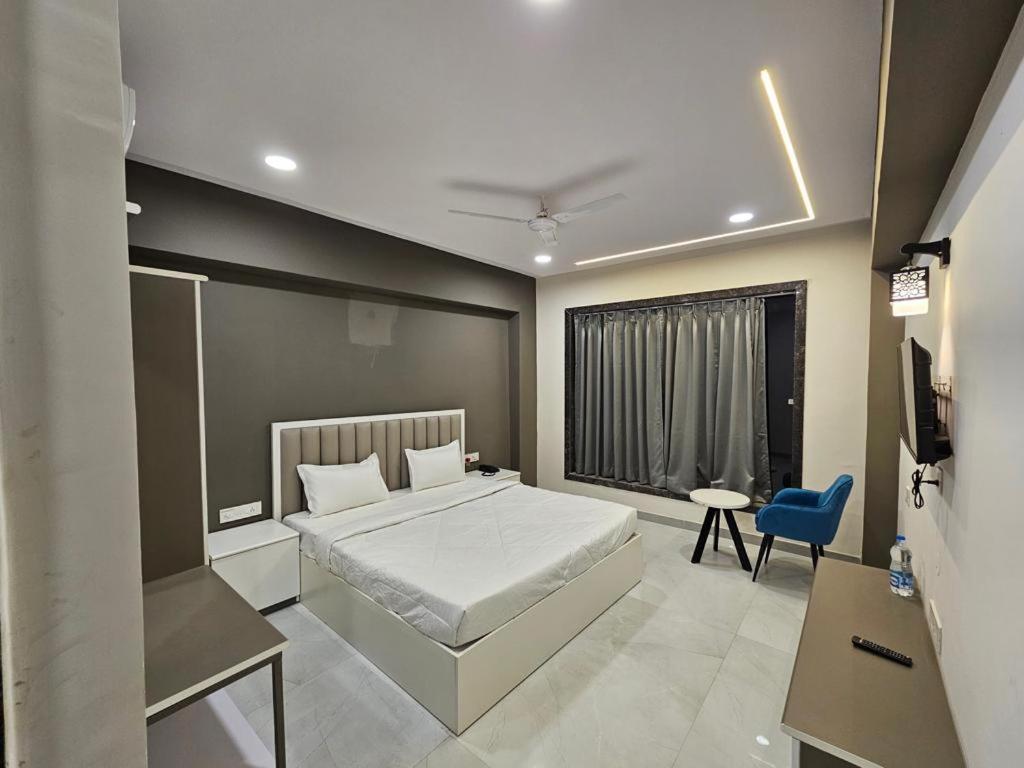 KondagaonHotel Rajhans的一间卧室配有一张床和一张蓝色椅子