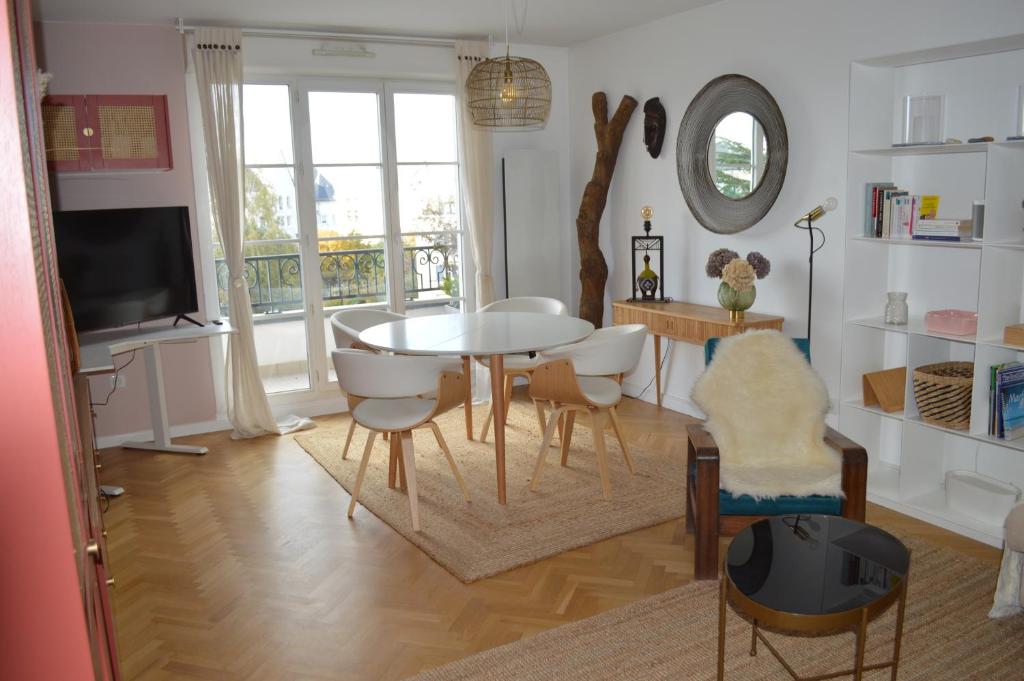 勒普莱西罗班松Cosy nest 6km from Paris的客厅配有桌椅和电视。