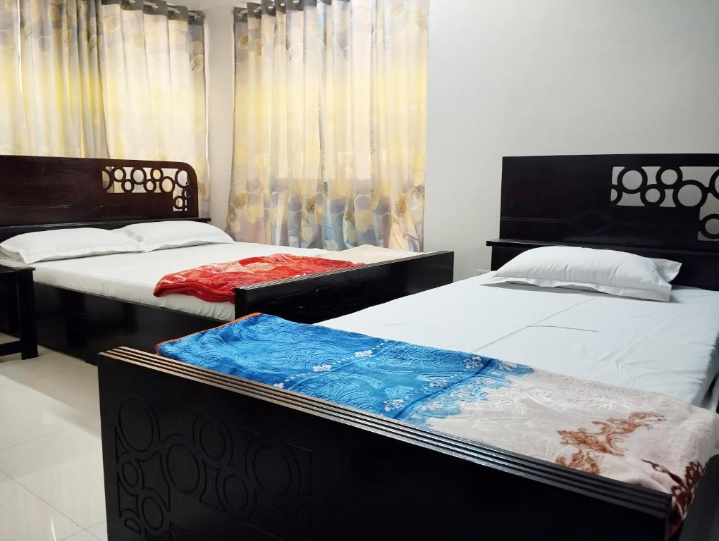 达卡Hotel Labbaik Dhanmondi的卧室内两张并排的床