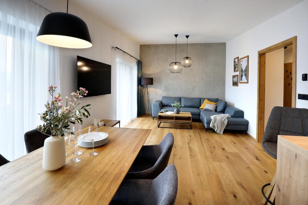 卢捷纳普德克利诺夫琴Apartmány Horizont的客厅配有桌子和蓝色沙发