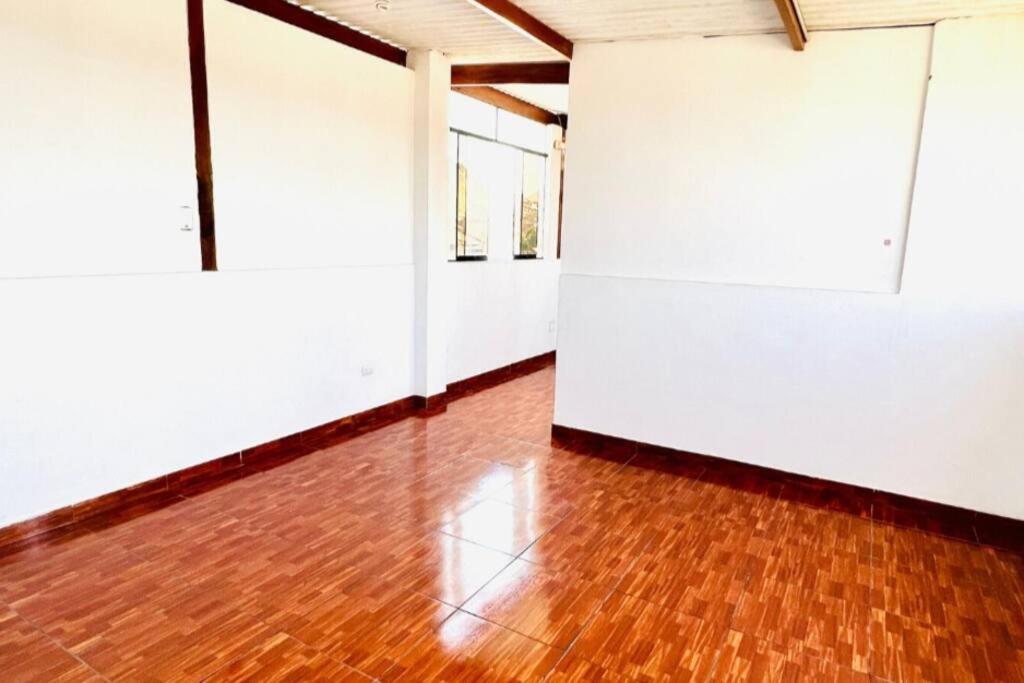 卢林Minidepartamento en Lurín的一间空房间,铺有木地板,拥有白色的墙壁