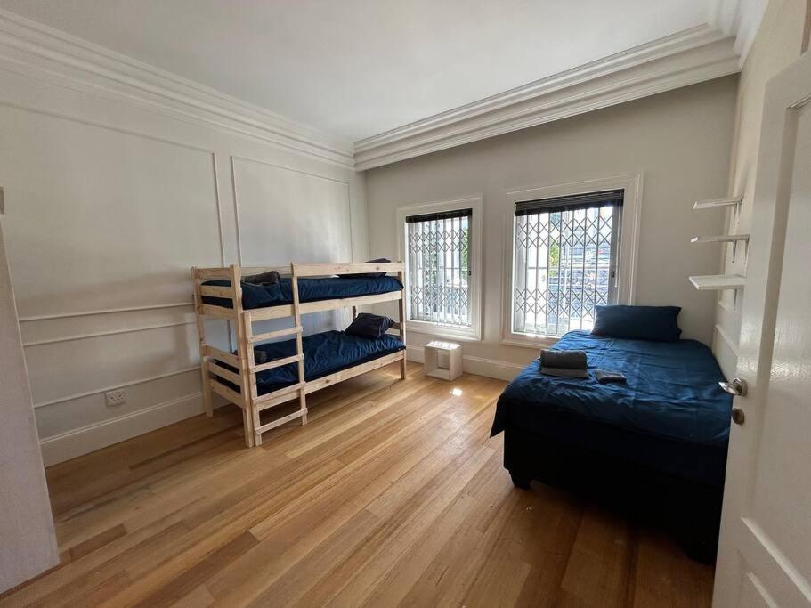 开普敦The Yellow House的一间卧室设有两张床,铺有木地板