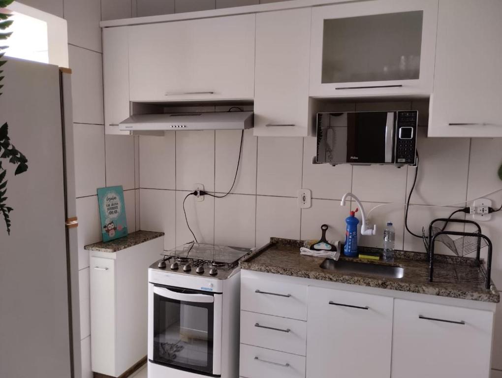 瓦拉达里斯州长市Andres' Home Vila Bretas的厨房配有白色橱柜和炉灶烤箱。