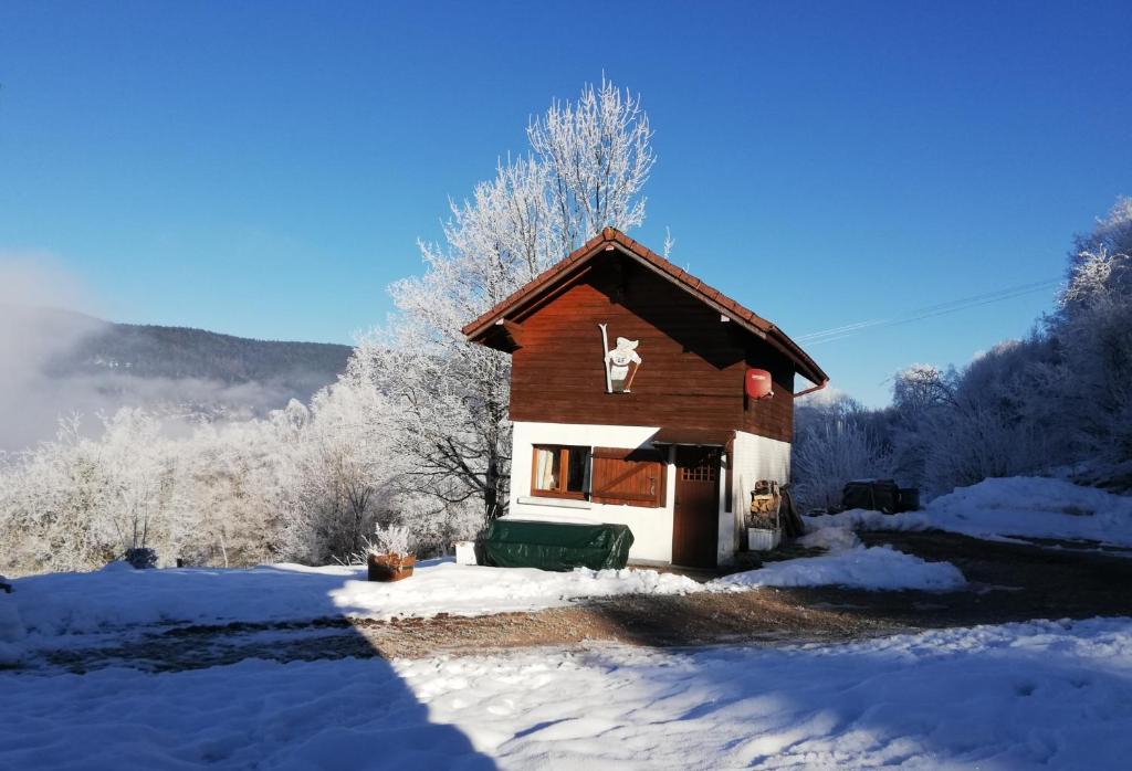 勒蒂约Location chalets的雪中的小小屋,有雪覆盖的树木