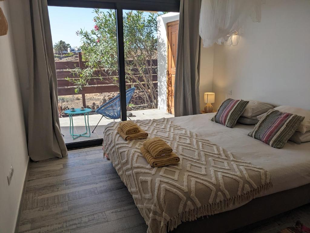 拉哈雷斯Casa Cocoon, Sun&Freedom, 8 mn from beaches, internet fiber的一间卧室设有一张床和一个大窗户