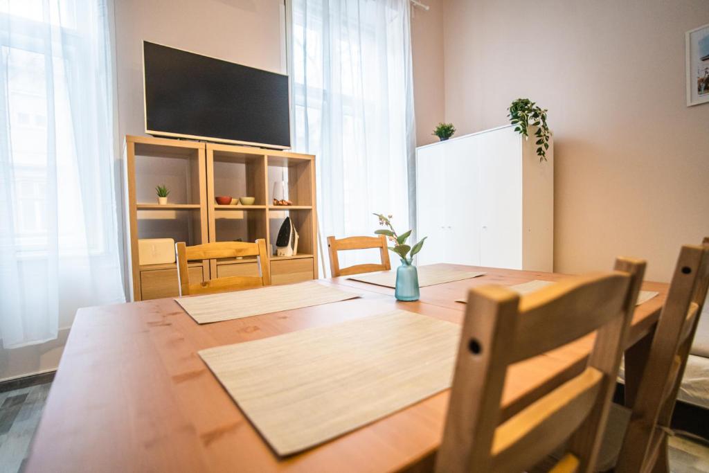 凯奇凯梅特Entire Flat in Kecskemét Center的用餐室配有木桌和平面电视。