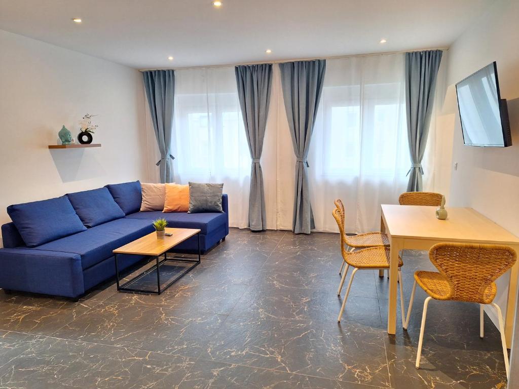普克斯多夫Apartment Purkersdorf bei Wien Top 4的客厅配有蓝色的沙发和桌子