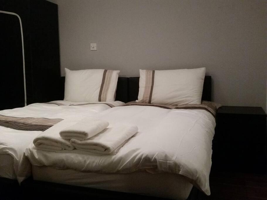 MordenLOVELY 1 BED FLAT WITH GOOD TRANSPORT LINKS.的一张带白色毯子和枕头的床
