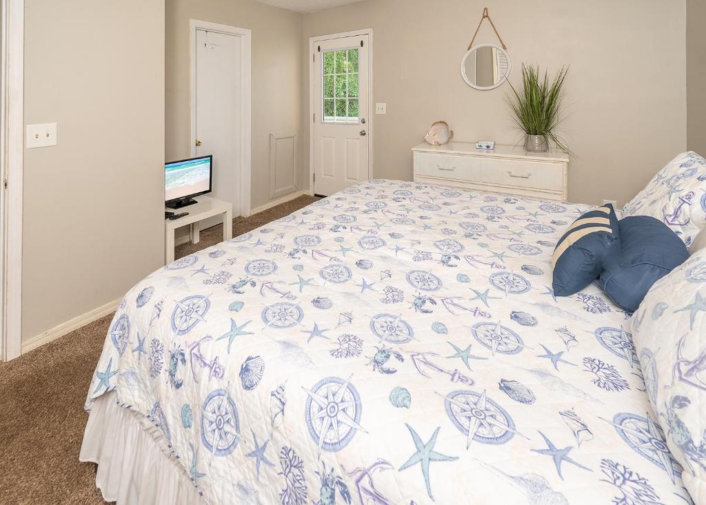 巴拿马城海滩Gulf Highlands Sea的一间卧室配有一张带蓝色和白色棉被的床