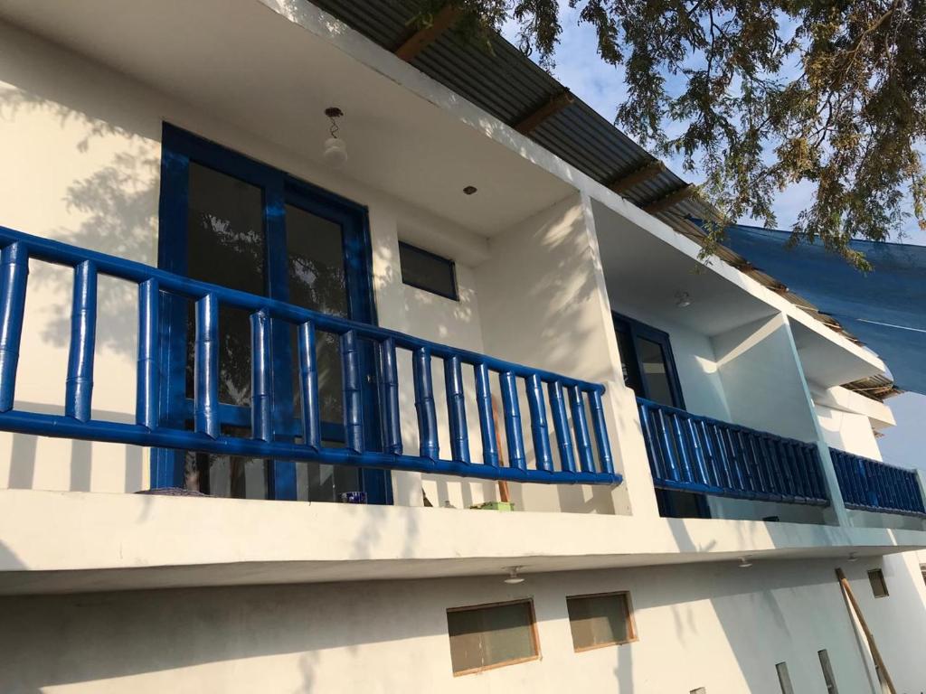 曼克拉Áncora Beach Hotel的白色的房子,设有蓝色的阳台