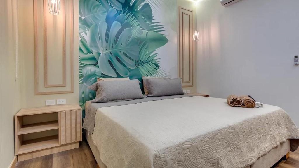 卡塔赫纳Miami Hotel Cartagena - Luxury Apartments的卧室配有一张大床,墙上挂有热带壁画