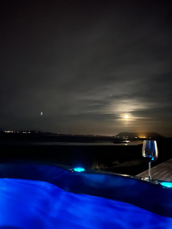 雷克霍特Luxury villa with hot tub & amazing view的一杯葡萄酒,晚上坐在桌子上