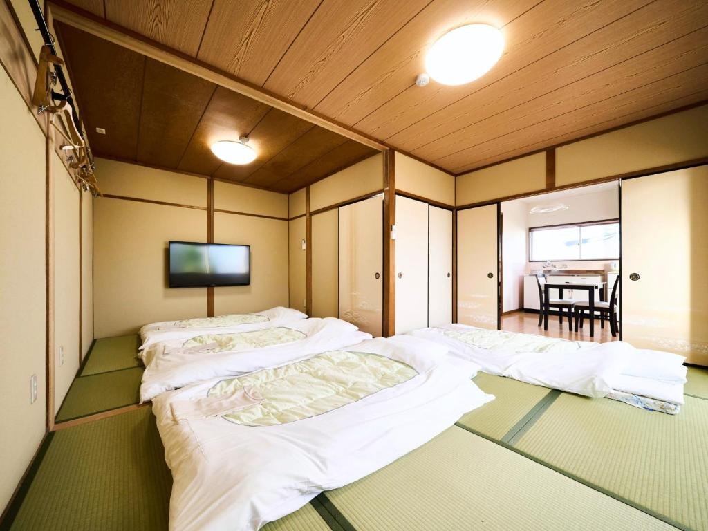 大垣Okasan Hotel - Vacation STAY 66120v的一间设有三张床和电视的房间