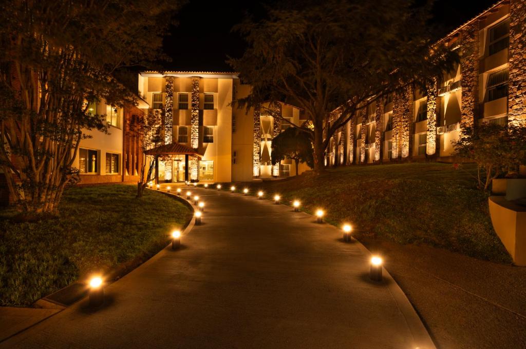 拉库布蕾Hotel Intersur La Cumbre的夜间在建筑物前的一条带灯光的人行道