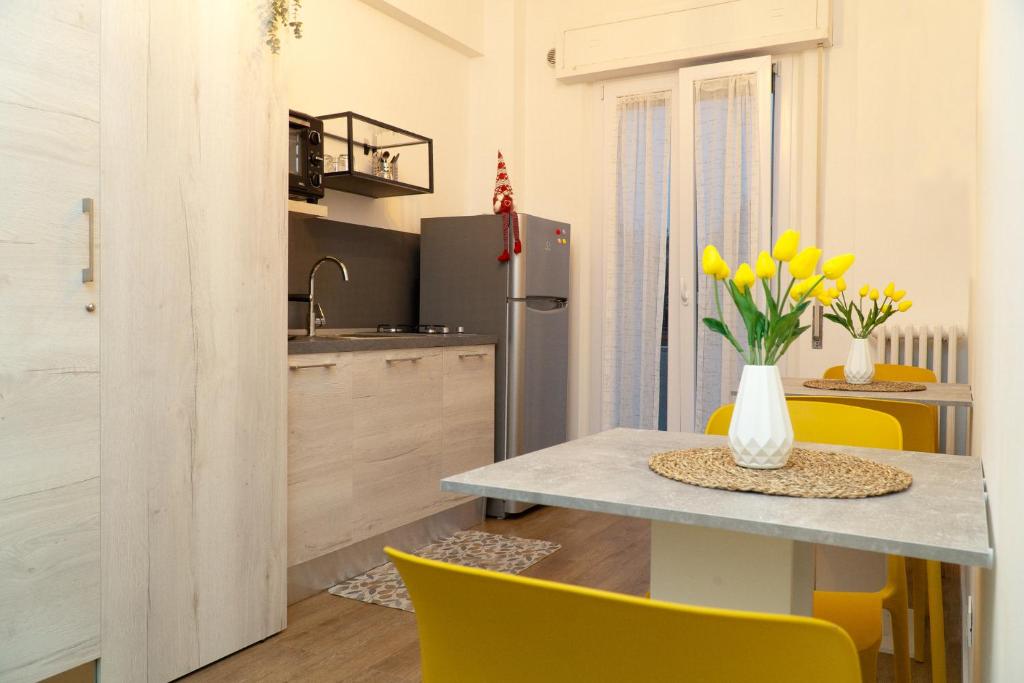 安科纳A casa di Serena的厨房以及带桌子和黄色椅子的用餐室。