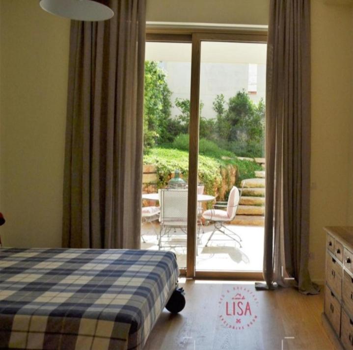 图里A CASA DA LISA (exclusive room)的一间卧室配有一张床,享有庭院的景色