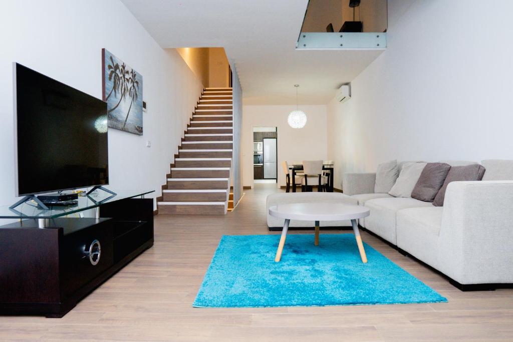 普拉亚Villa Santiago的客厅配有白色沙发和蓝色地毯。