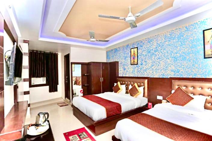 TājganjHotel The Blue rose 500mtr Taj的一间卧室配有两张床和吊扇