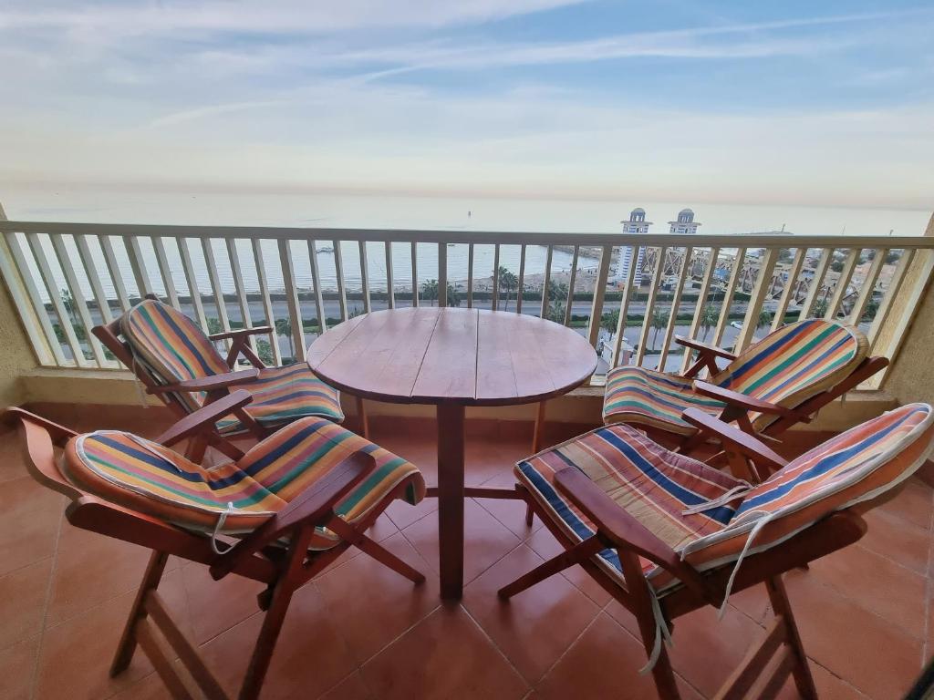 艾因苏赫纳Porto sokhna Pyramids Apartments的一个带桌椅的海景阳台