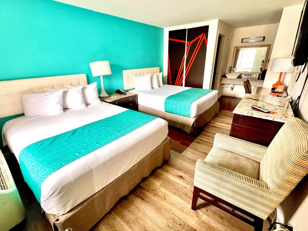 里诺Howard Johnson by Wyndham Downtown Reno的酒店客房,配有两张床和椅子