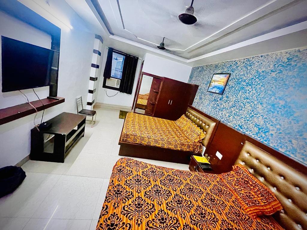 Nagla DhīmarHotel AC family Rooms的酒店客房设有两张床和电视。