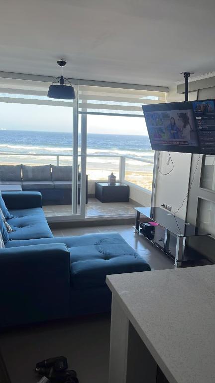 拉塞雷纳Resort Laguna del mar的客厅配有蓝色的沙发和电视