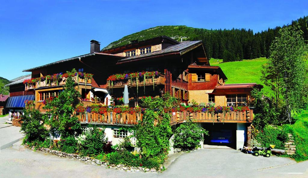 沃瑟姆阿尔伯格Biobauernhof Gehrnerhof am Arlberg的阳台上的鲜花盛开的大房子