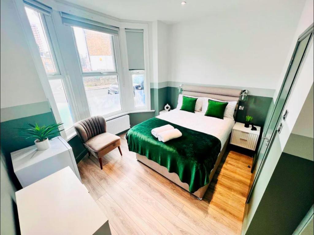 伦敦En-suite Room look like hotel的小房间设有一张床和一把椅子