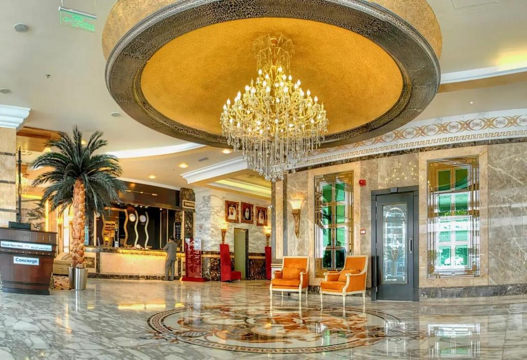 沙迦Sharjah Palace Hotel的大楼内带吊灯和椅子的大堂