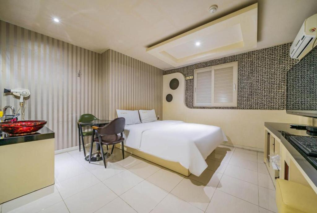 巨济S plus motel的酒店客房配有一张床铺和一张桌子。