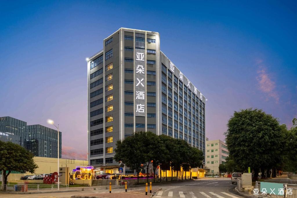 宝安深圳宝安机场航城亚朵X酒店的一座高大的建筑,在建筑的一侧写字