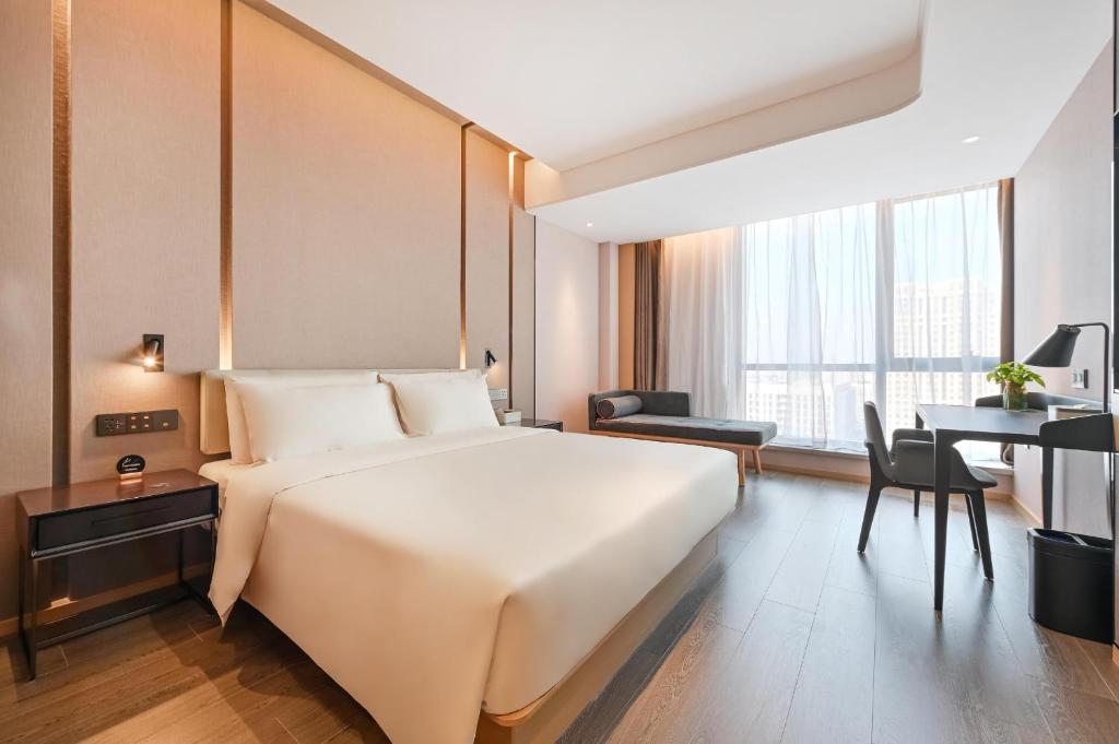 北京北京朝阳北路长楹天街亚朵酒店的卧室配有一张白色大床和一张书桌