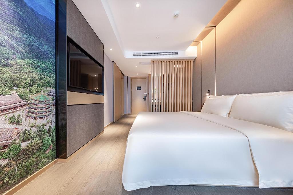 成都成都春熙路天府广场地铁站亚朵酒店的卧室配有一张白色大床和一台平面电视。