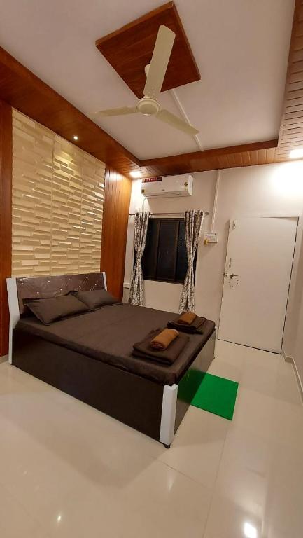 甘帕普拉Vighnaharta Homestay的一间卧室配有一张带吊扇的床