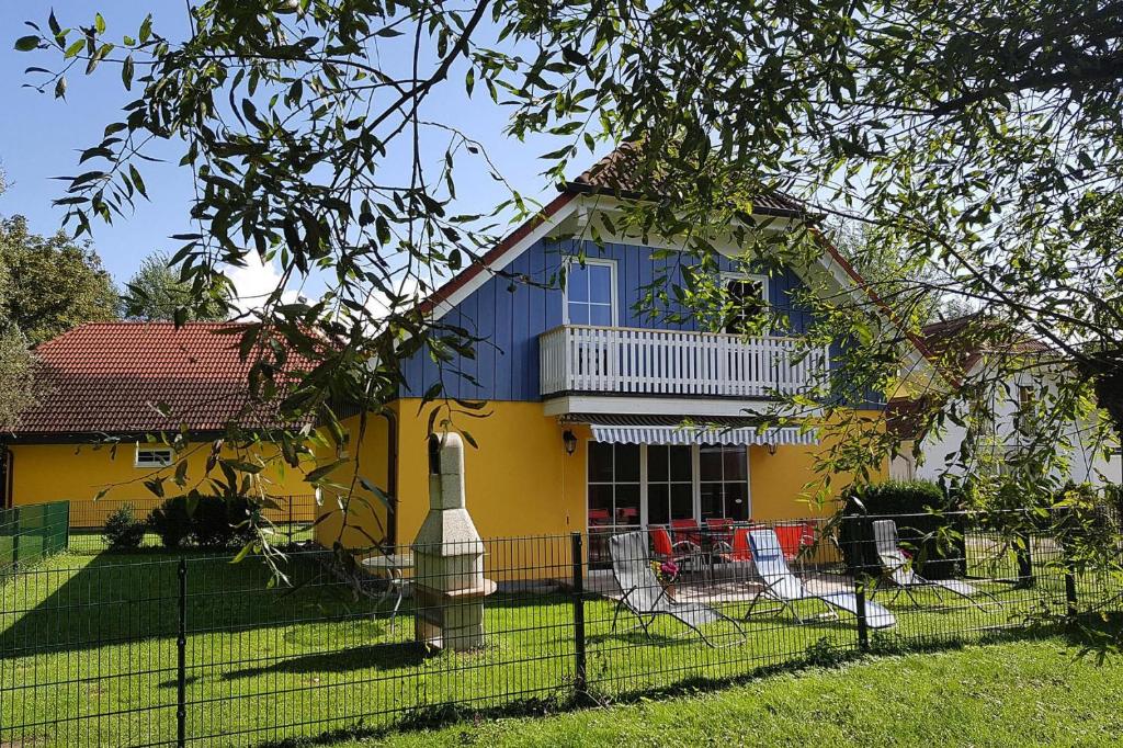 VerchenCottages at the Kummerower See Verchen的黄色和蓝色的房子,带围栏