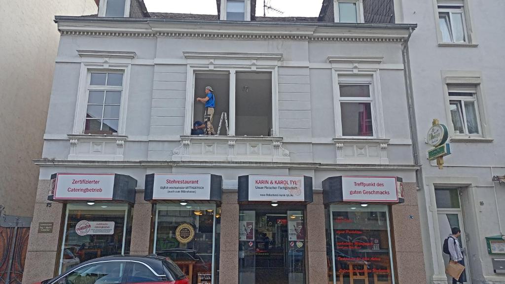 特里尔St Maximin City Ferienwohnungen的站在建筑物窗户上的男人