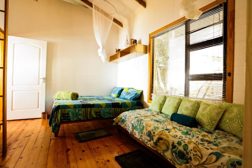 Ponta MalanganePequena Casa Holiday Home Malongane的带沙发和窗户的客厅