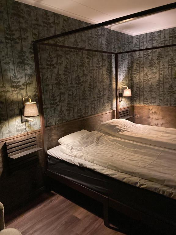谢莱夫特奥Hotell Stensborg的卧室配有一张床,墙上配有两盏灯。