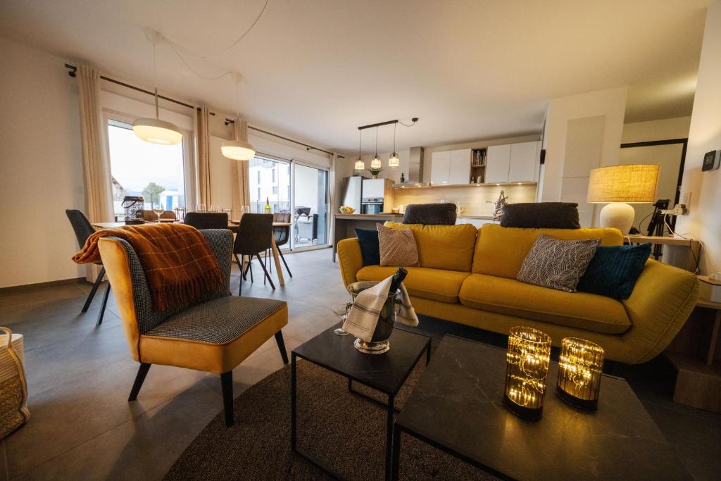 PublierL'Escale du Léman的一间带黄色沙发的客厅和一间厨房