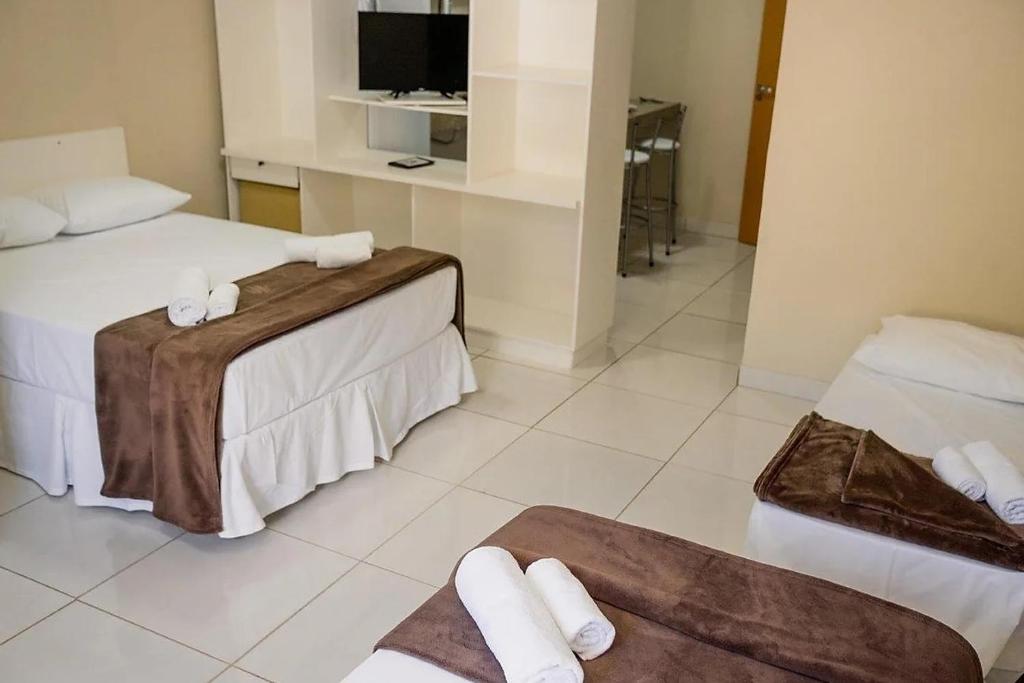 São Gonçalo do Rio AbaixoIron Flat Residence Service的酒店客房设有两张床和电视。